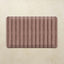 Maroon kitchen mat with striped pattern on a beige background