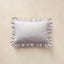A rectangular throw pillow with ruffled edges, featuring a fine horizontal stripe pattern in light blue and white, displayed against a neutral beige background.
