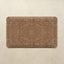 A rectangular kitchen mat with rounded corners featuring an intricate brown damask pattern, displayed flat against a textured beige background.