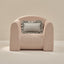 Pink armchair with a striped pattern and a gray pillow on a beige background