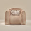 Checkered armchair with a decorative pillow on a beige background