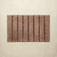 Brown bath rug with black stripes on a beige background