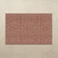 Rectangular area rug with a floral pattern on a beige wall.