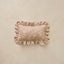 A rectangular decorative pillow with ruffled edges and a subtle floral pattern, shown against a textured beige background.
