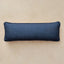 A rectangular lumbar pillow with a dark blue and teal geometric pattern, displayed horizontally against a neutral beige background.
