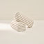 Two striped cylindrical armrests on a beige background