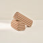 Two striped cylindrical armrests on a beige background