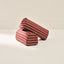 Two striped cylindrical armrests on a beige background