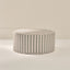 Round ottoman with striped pattern on a beige background