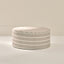 Round ottoman with striped pattern on a neutral background