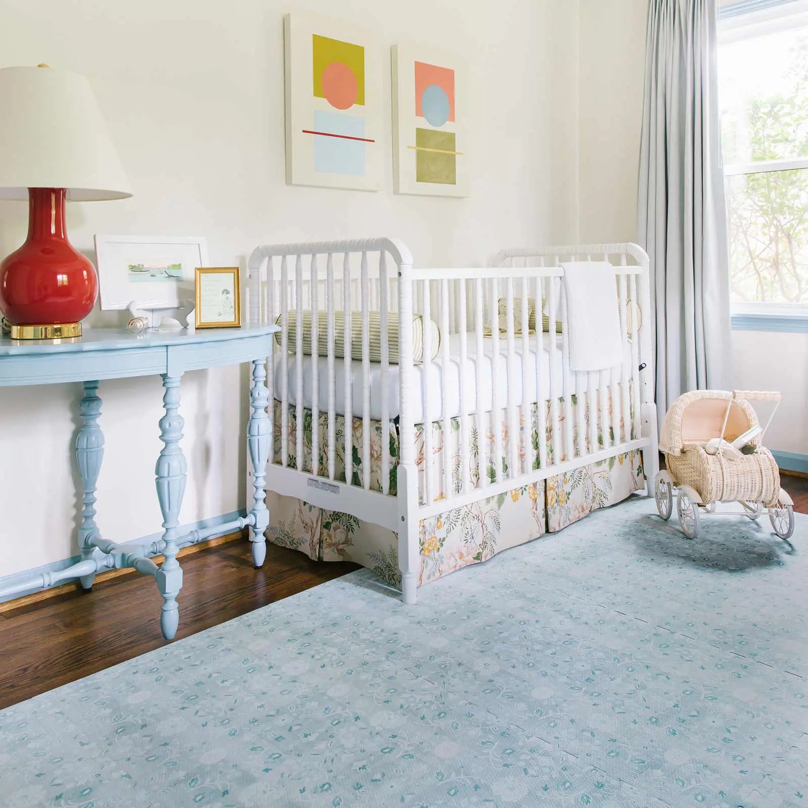 Powder blue floral pattern play mat shown in nursery with crib and toy buggy
