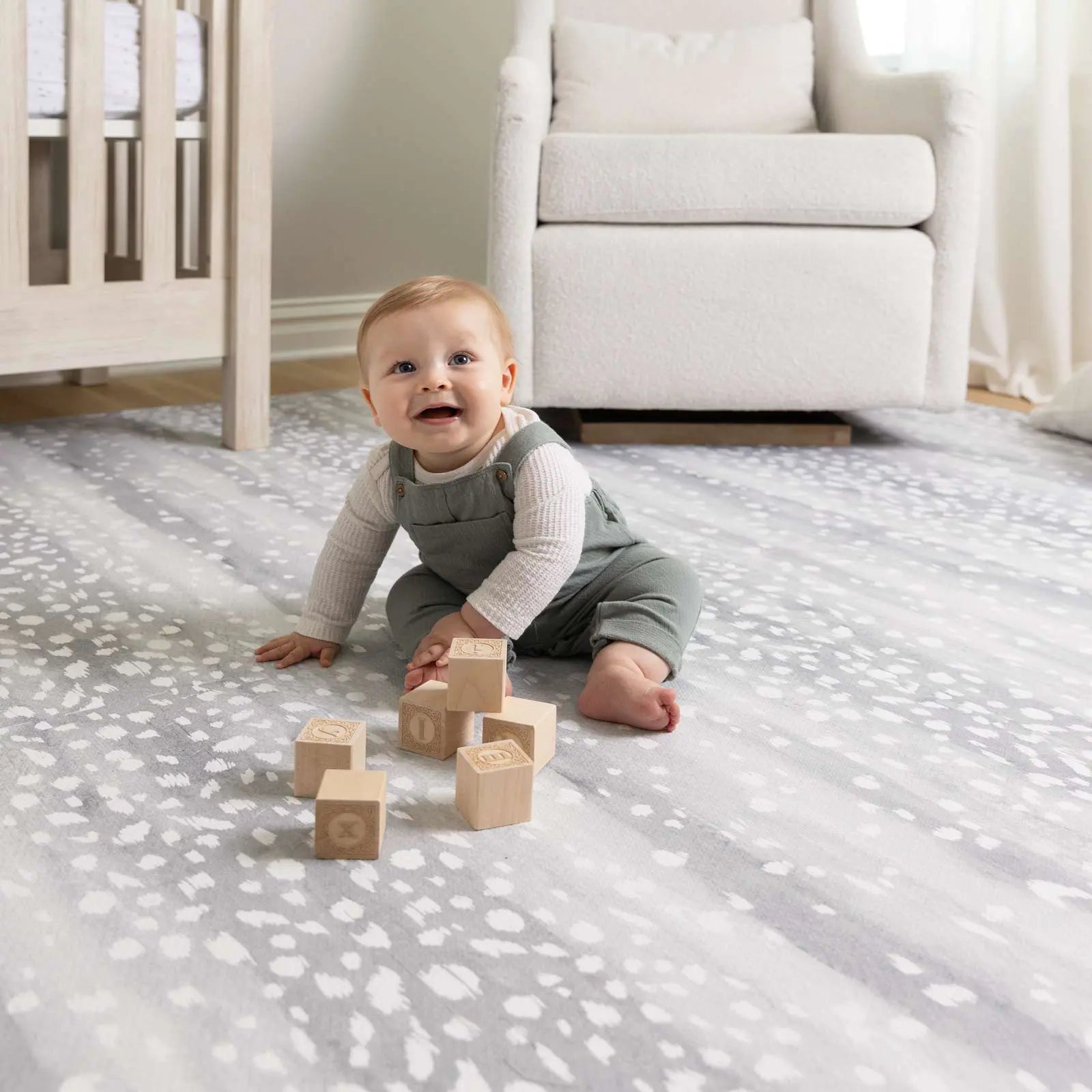 Fawn silver gray animal print play mat with baby playing with wooden blocks