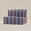 Striped brown and blue play couch cushion on a beige background