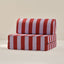 Red and purple striped play couch cushion on a beige background
