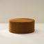 A brown upholstered ottoman with a removable cover, placed on a white surface against a neutral background.