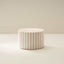 A cylindrical soft furniture ottoman with beige and white checkered fabric upholstery.