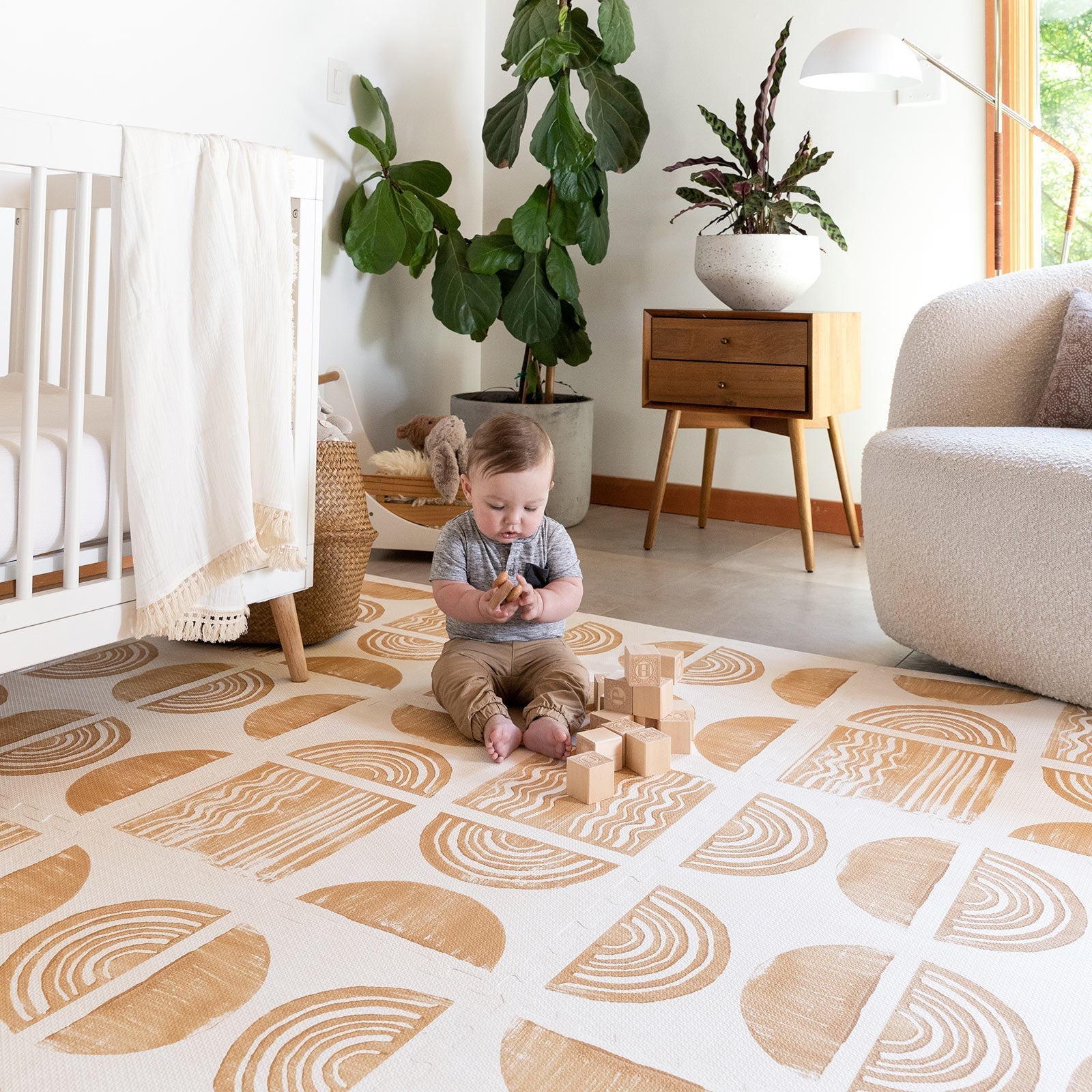 Ada modern minimalist baby play mat in Sunflower, mustard yellow and off white. Shown in a nursery with baby playing with blocks.