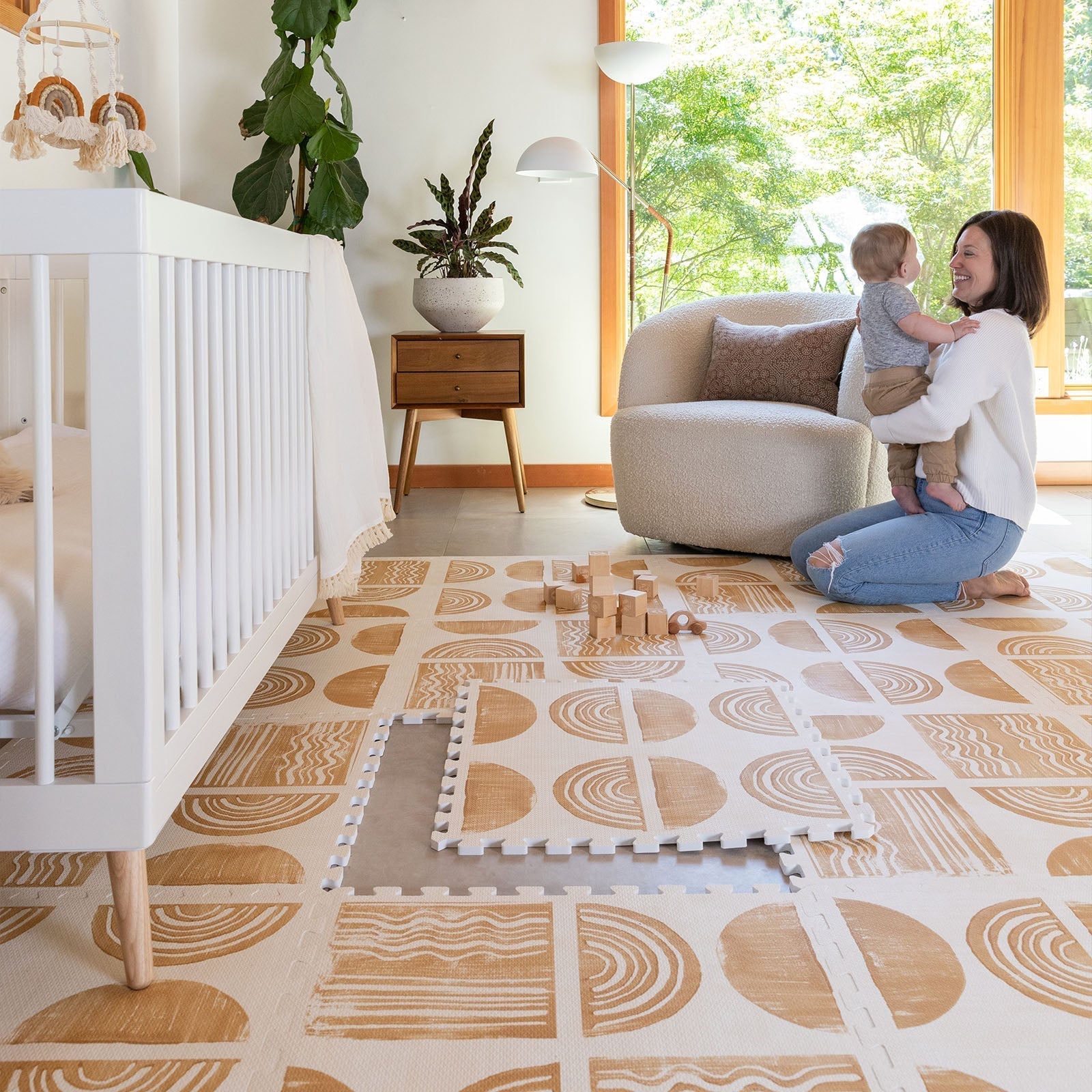 Ada modern minimalist baby play mat in Sunflower, mustard yellow and off white. Shown in a nursery with one tile lifted in the center and Mom and baby playing.