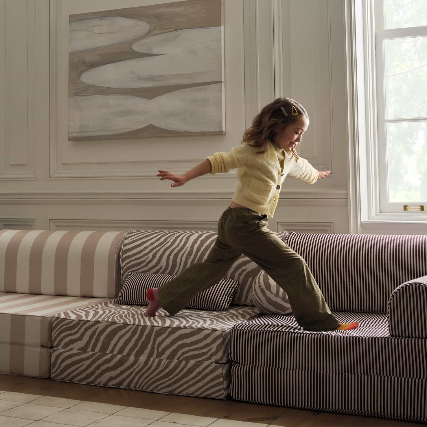 girl running atop house of noa modular couch