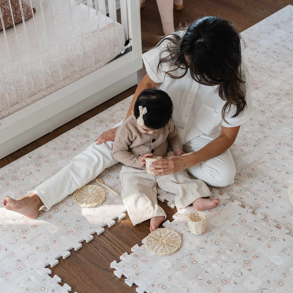 mom playing with baby on play mat