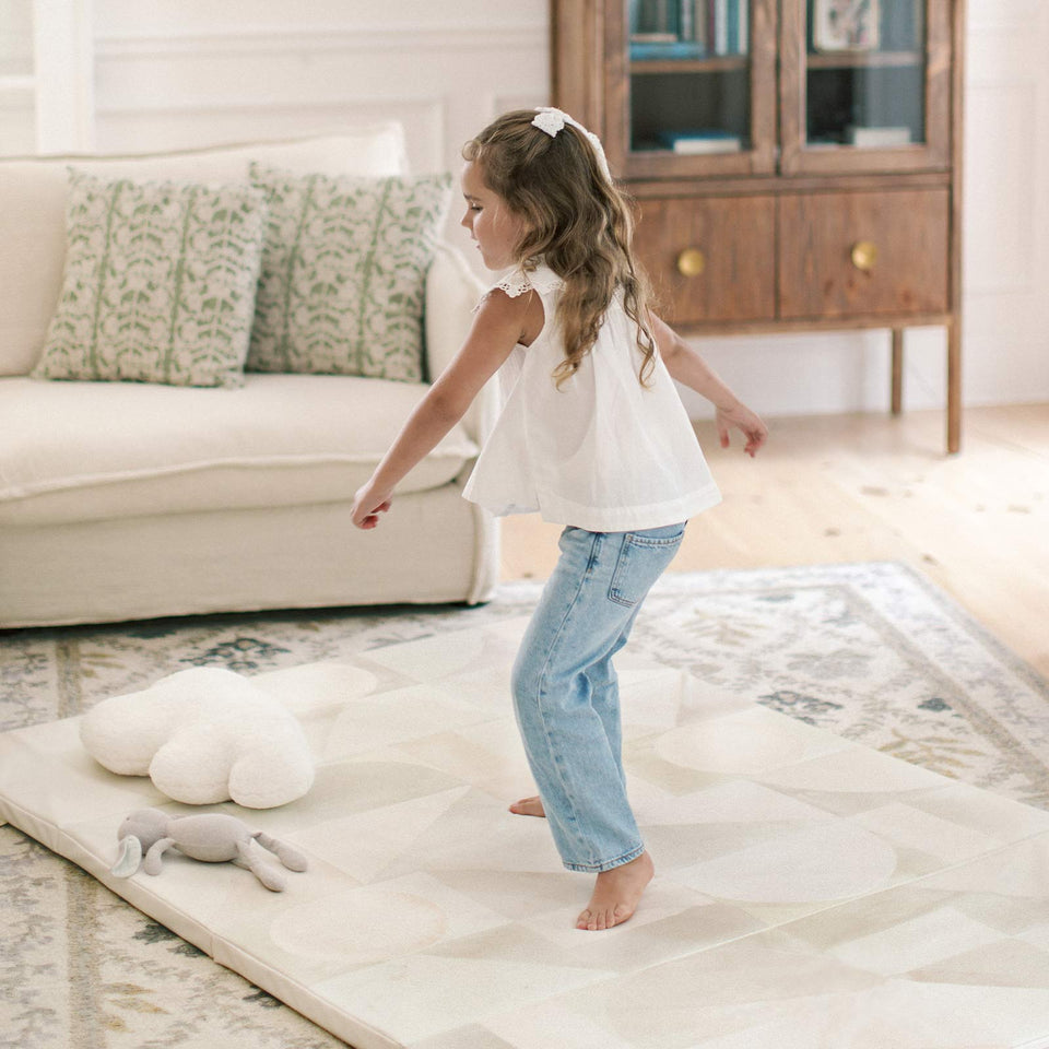 child playing on top of a house of noa tumbling mat