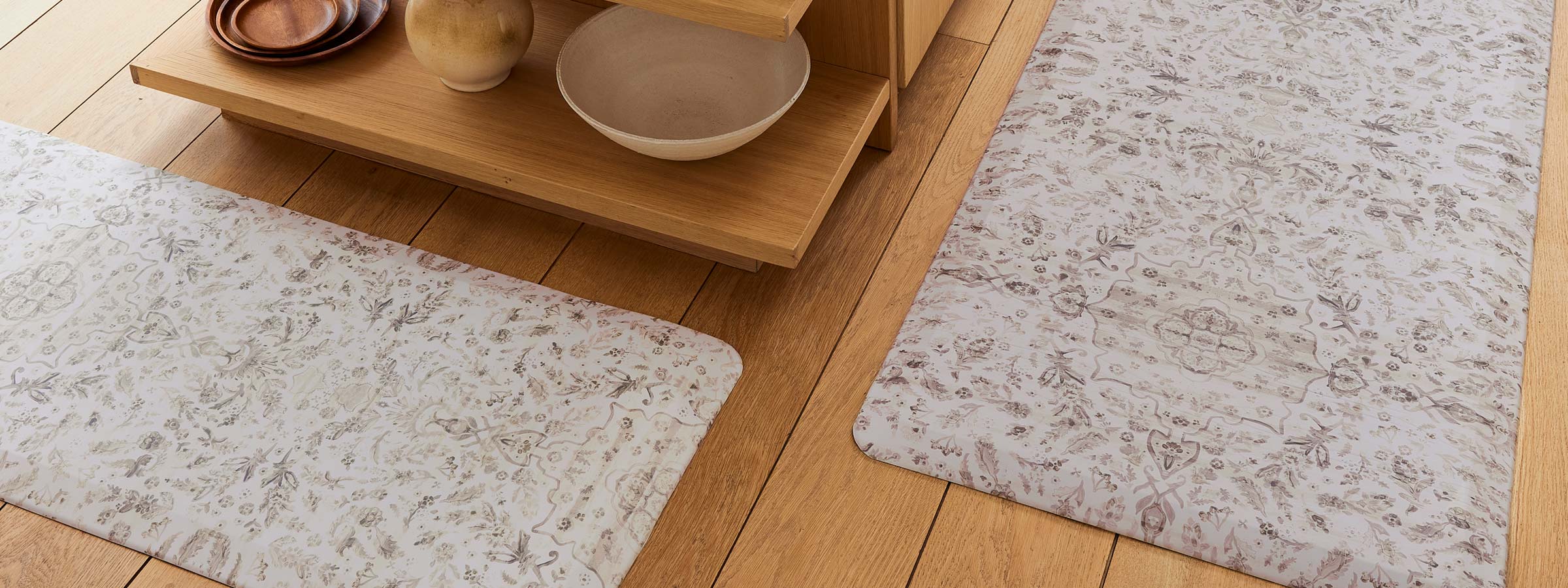 emile latte neutral floral print standing mat shown on wooden kitchen floor in sizes 22x36 and 22x72
