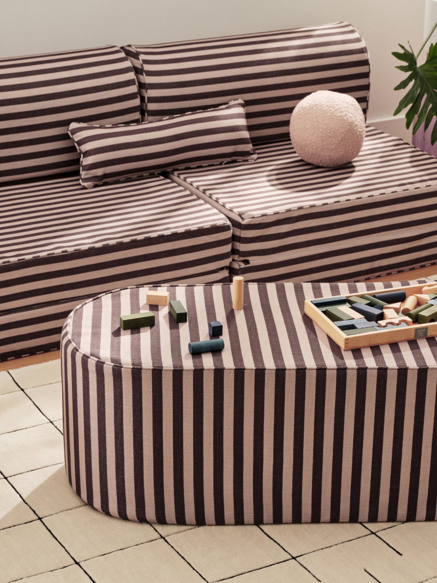 Striped play couch, ottoman, and pillows with children's toys