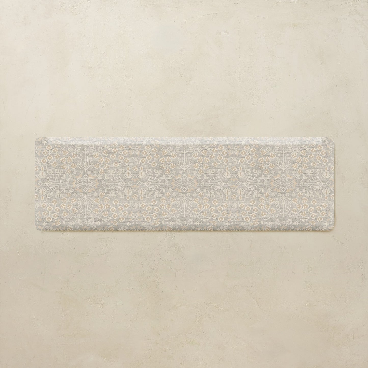 Rectangular rug with a subtle floral pattern on a beige background