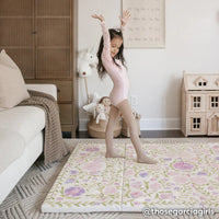suzette lilac purple and green floral tumbling mat shown in a play room with little girl in leotard posing on the mat. @thosegarciagirls written in lower right hand corner.