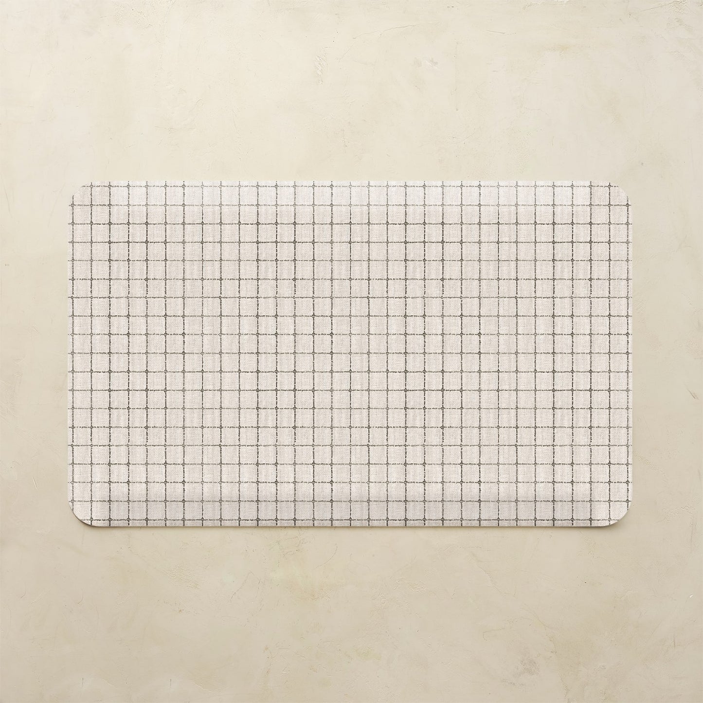Grid-patterned mat on a beige background