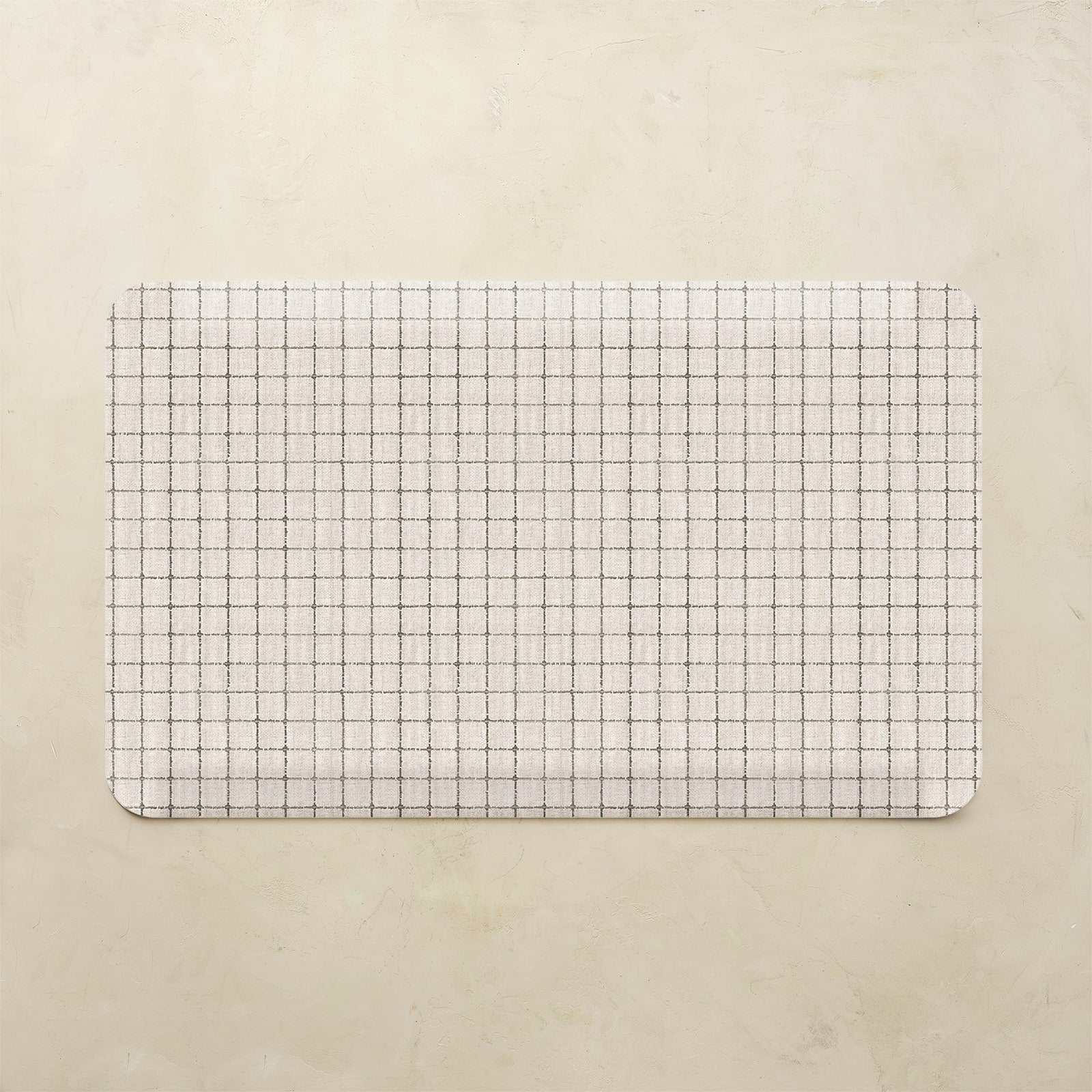 Grid-patterned mat on a beige background