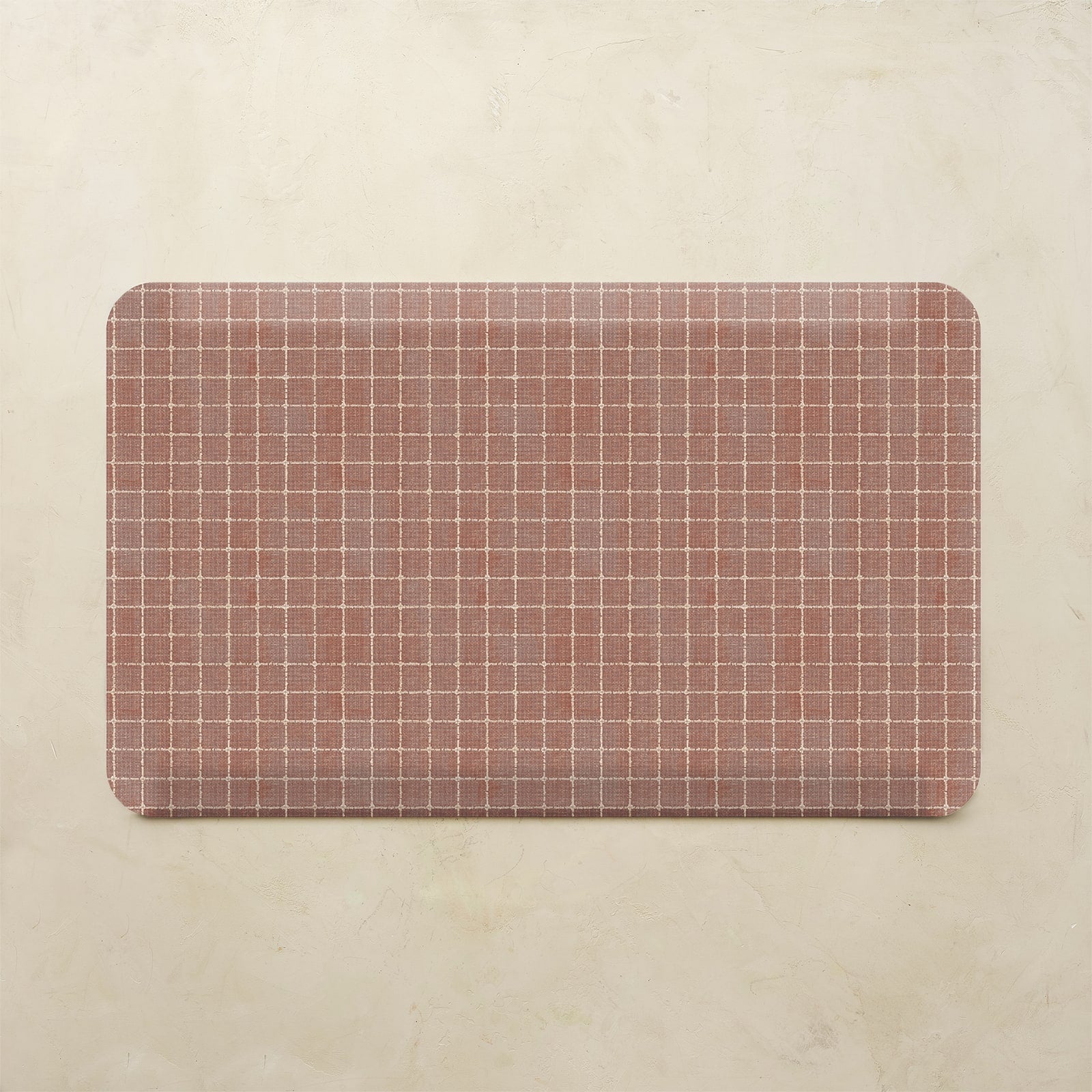 Rectangular kitchen mat with grid pattern on a beige background