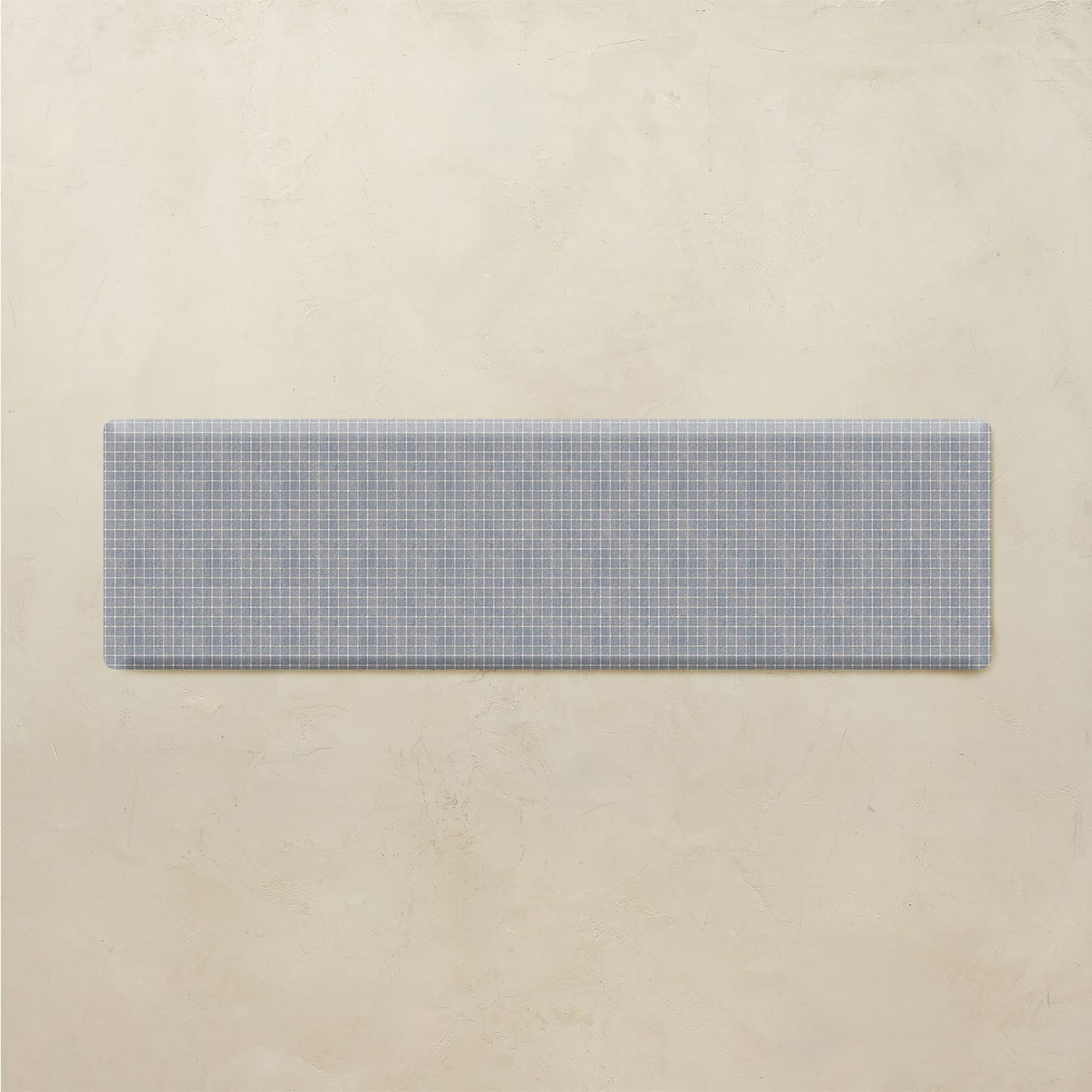 Rectangular blue and white checkered mat on a beige background