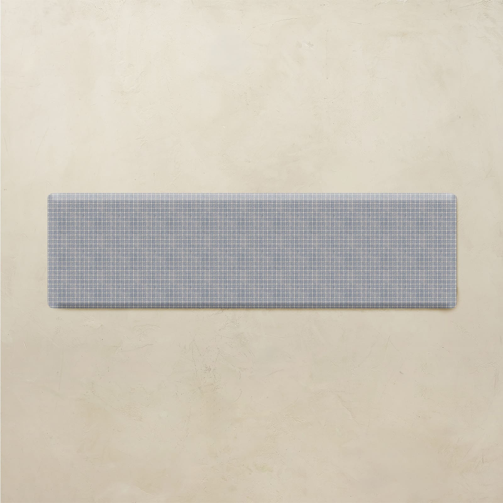 Rectangular blue and white checkered mat on a beige background