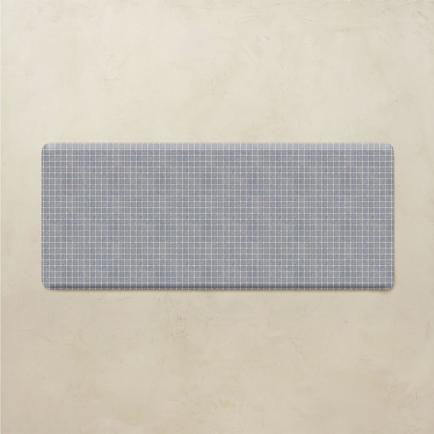Rectangular blue grid-patterned mat on a beige background