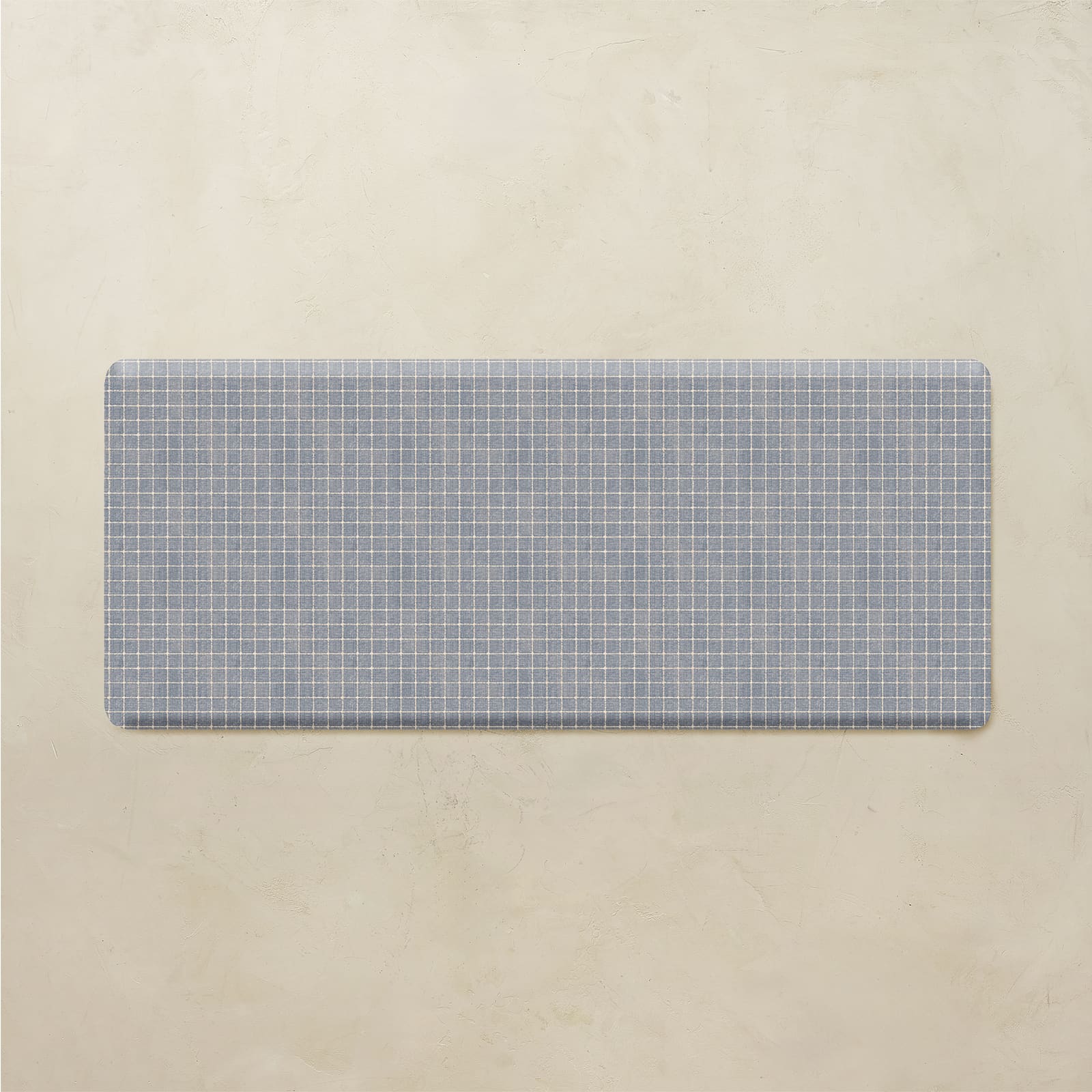 Rectangular blue grid-patterned mat on a beige background