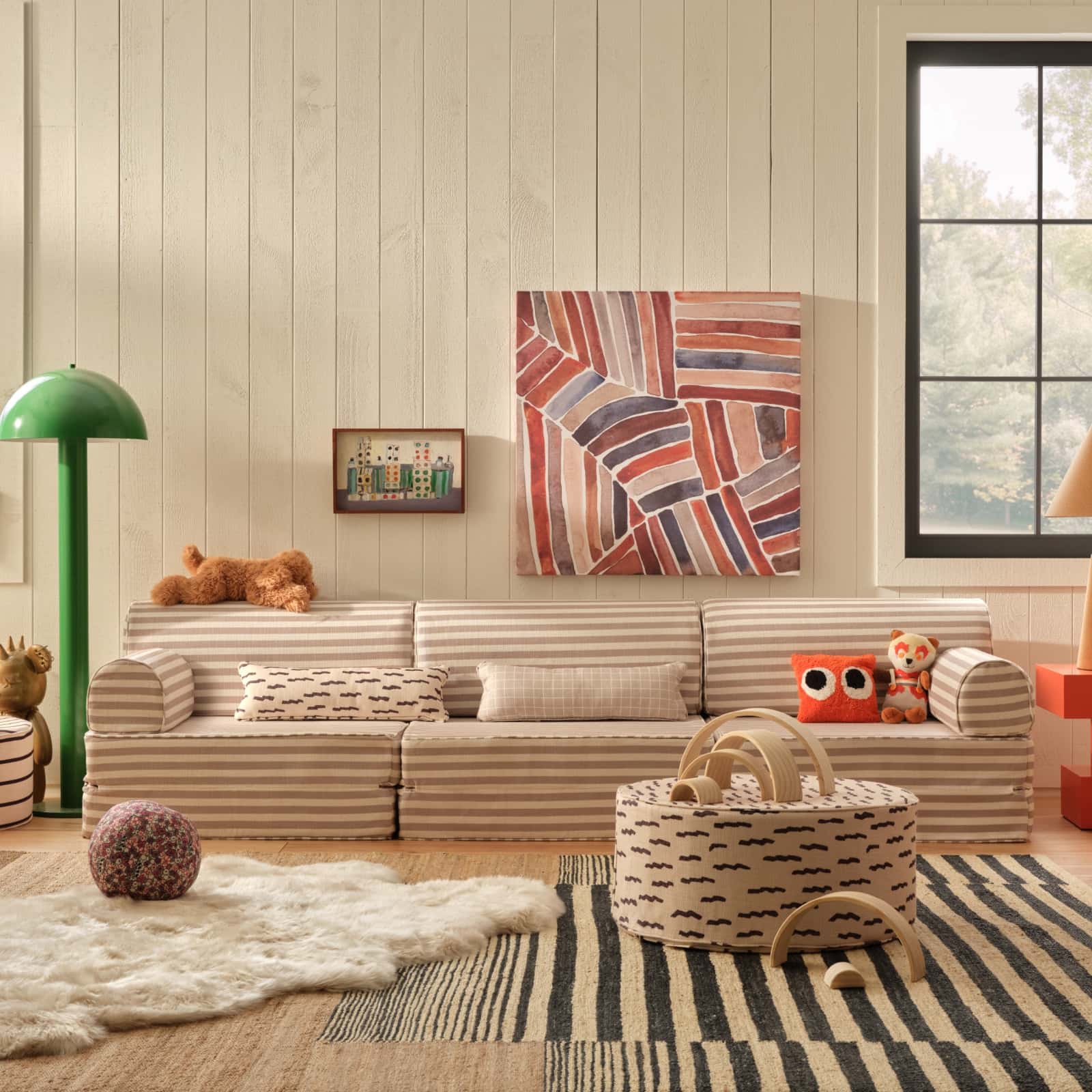 Modern living room with a striped sofa, colorful abstract painting, and decorative items.