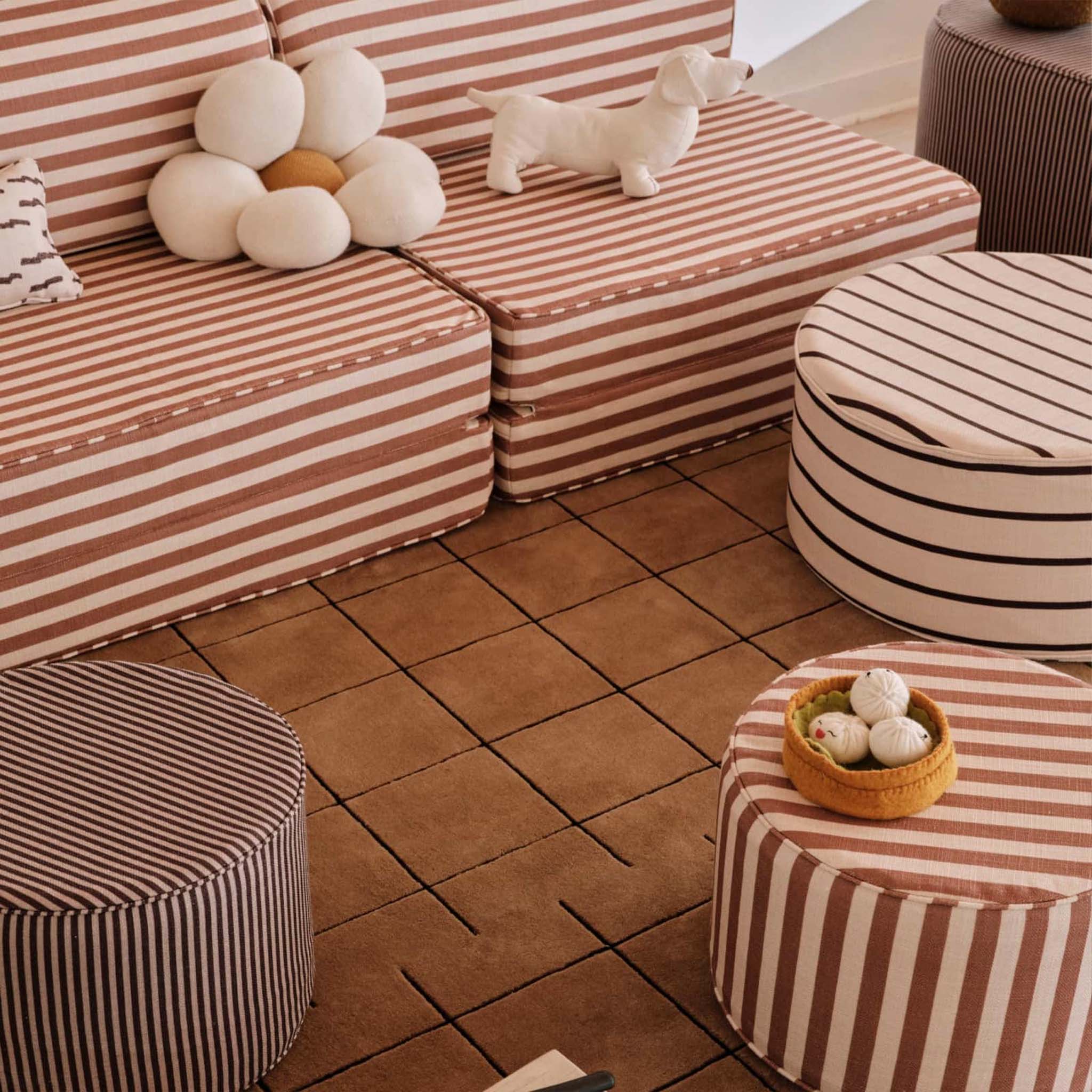 Striped sofa and ottomans with decorative items on a tiled floor