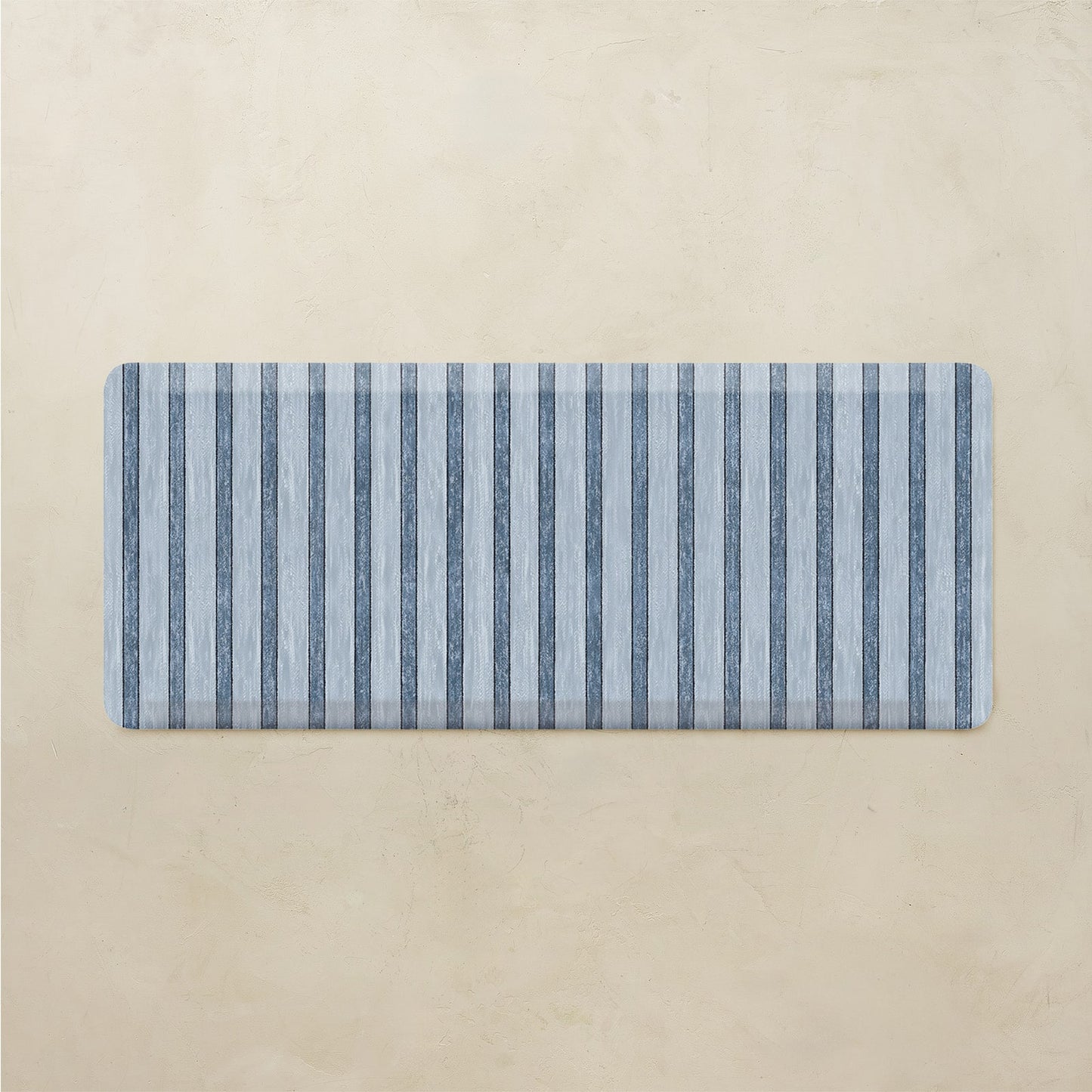 Rectangular mat with blue and gray striped pattern on a beige background