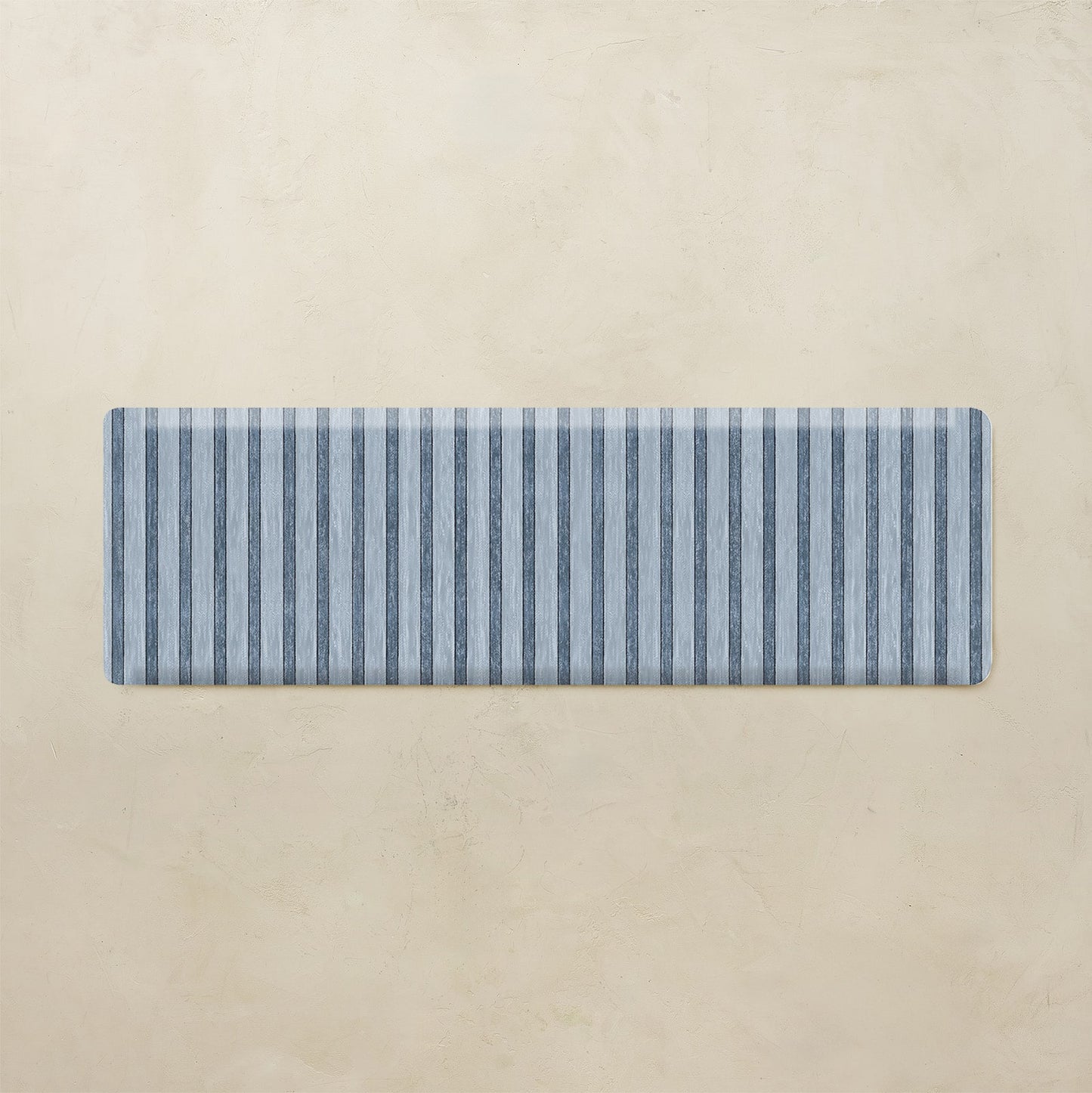 Rectangular blue and white striped mat on a beige background