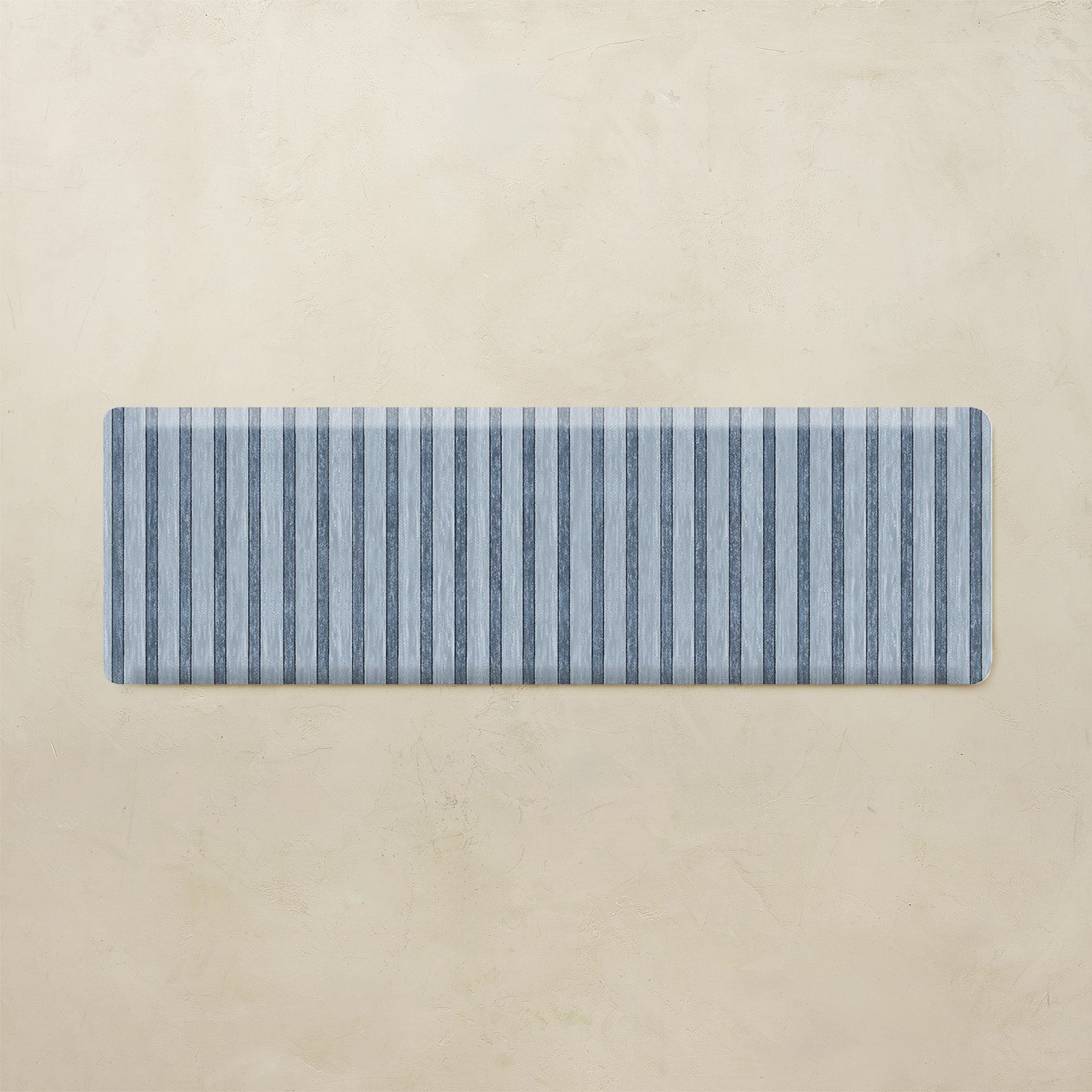 Rectangular blue and white striped mat on a beige background