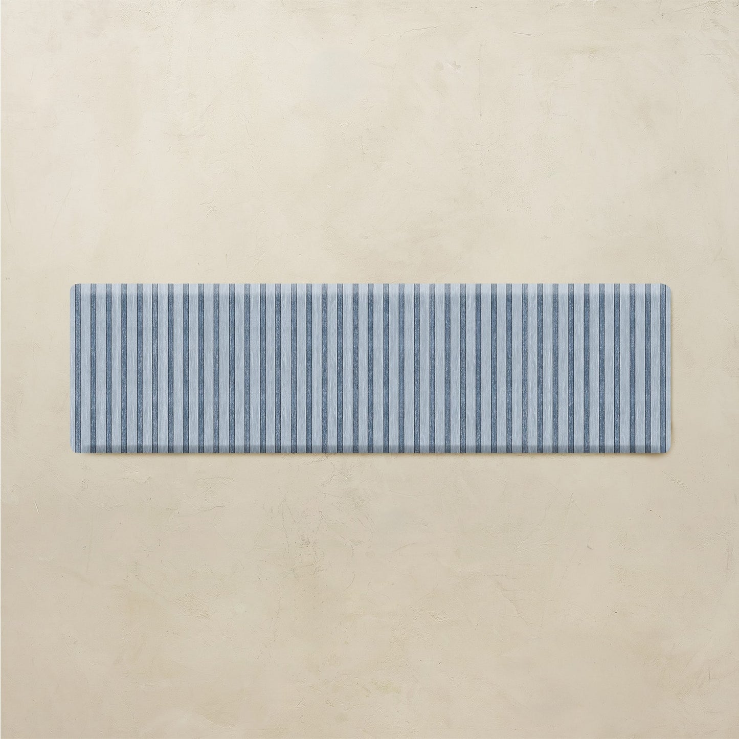 Rectangular blue and white striped mat on a beige background