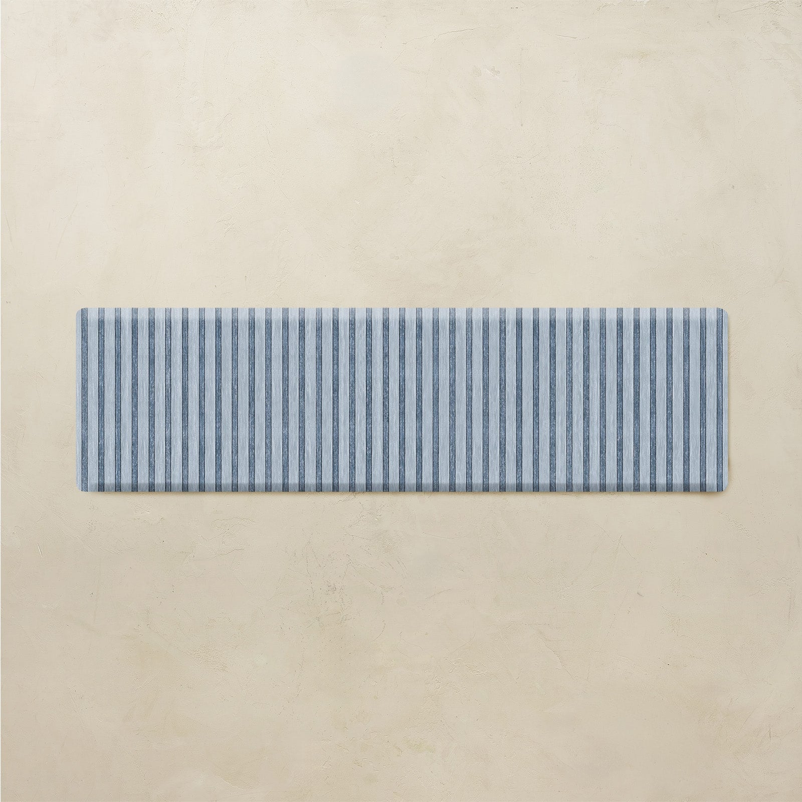 Rectangular blue and white striped mat on a beige background