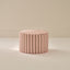 Striped ottoman with pink and brown vertical stripes on a beige background
