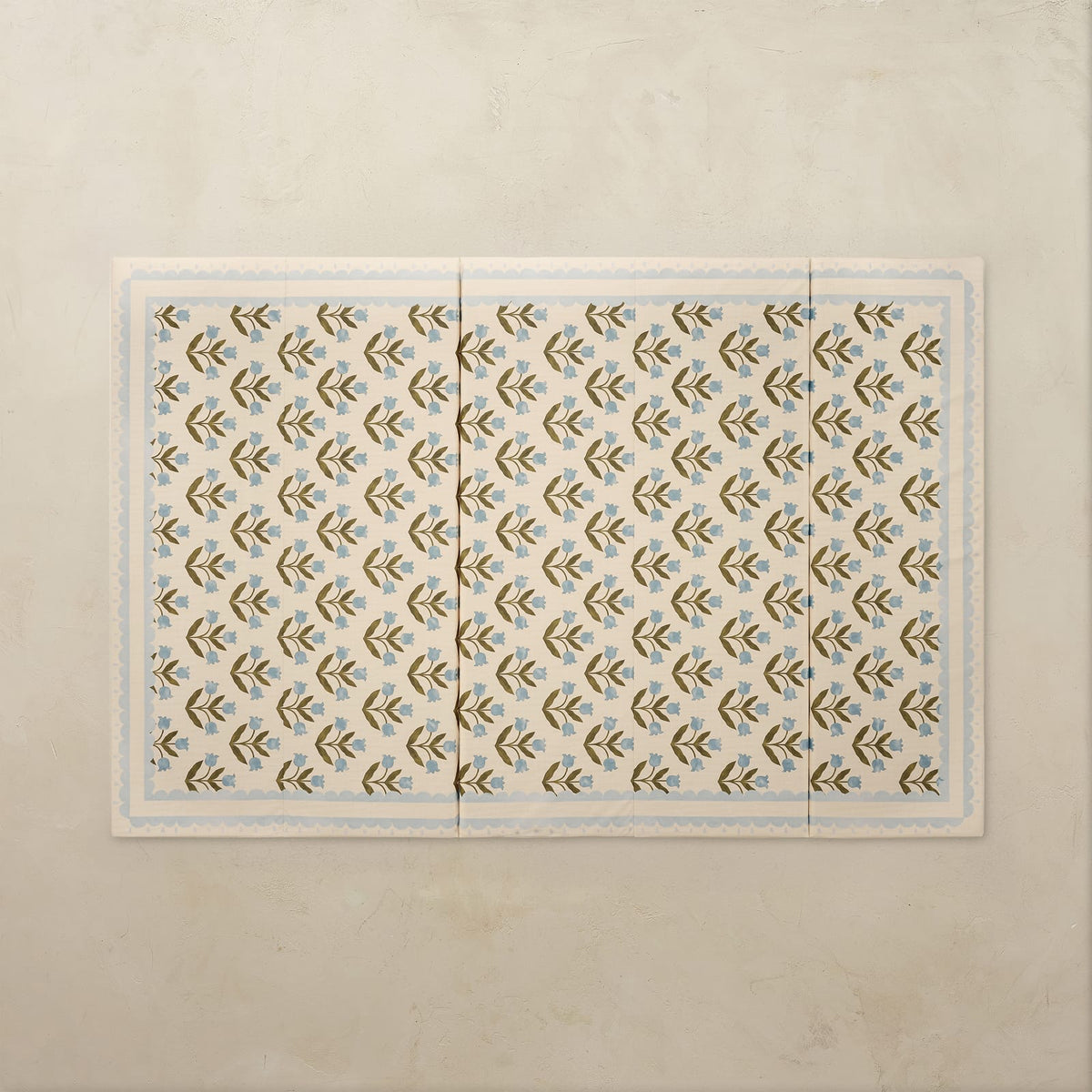 Delilah Cornflower 5x7.5 tumbling mat with a blue tulip pattern and scalloped light blue border on a cream base