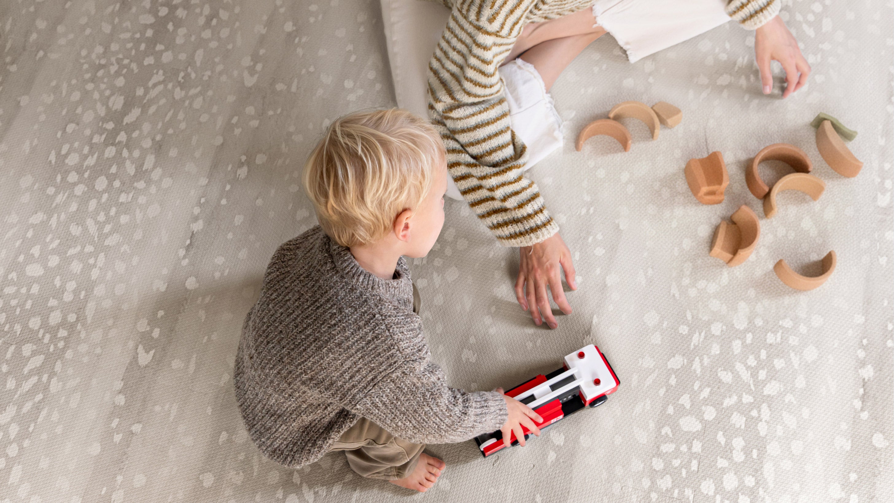 Child and parent playing with toys on the Fawn Play Mat in Shea