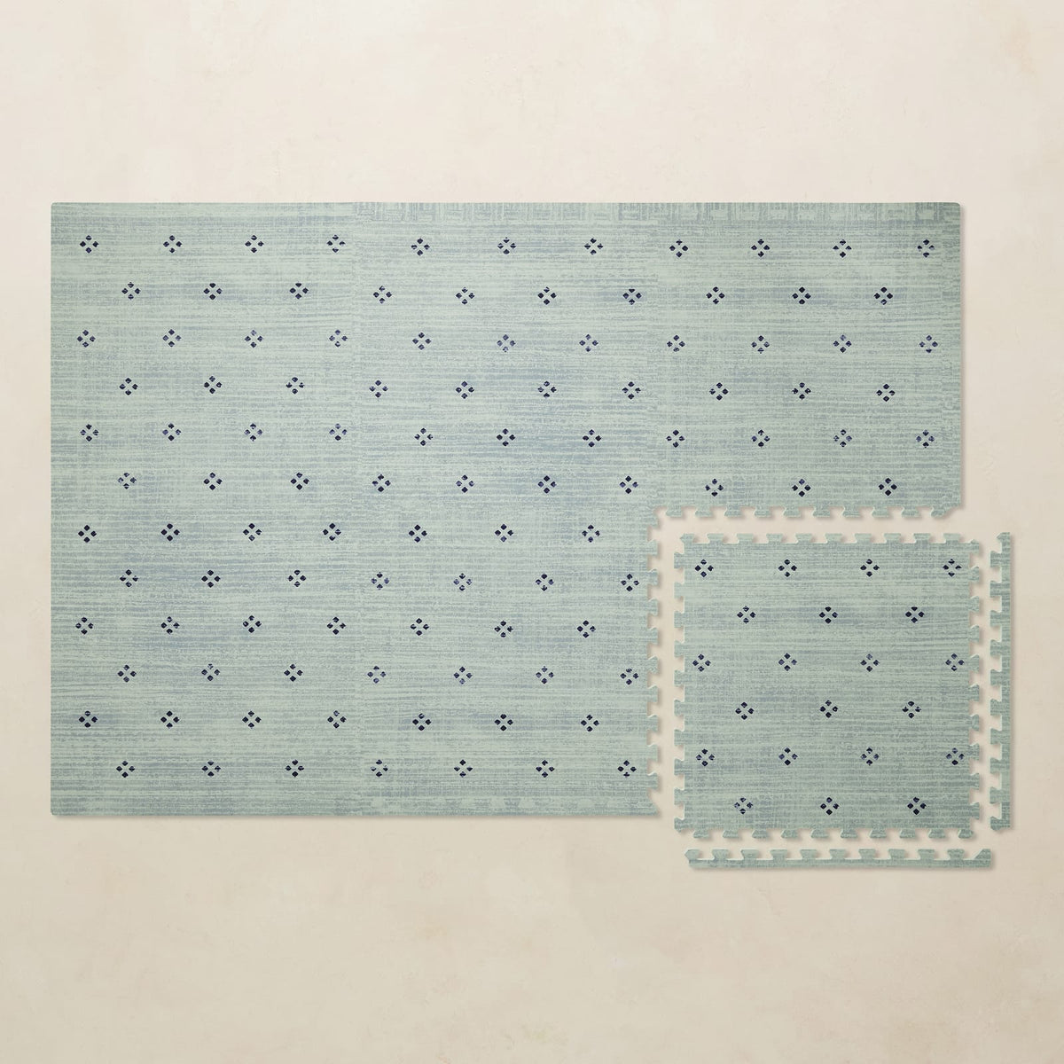 A 4x6 seafoam Dover foam play mat shown beside a single interlocking tile to compare sizes, photographed from above on a beige background.