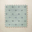 A square interlocking foam play mat tile in soft seafoam with a navy diamond dot motif, shown from above on a light beige background.