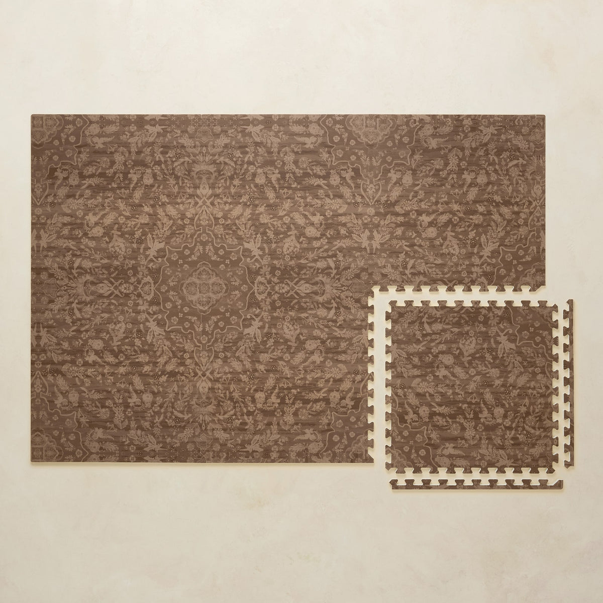 A 4x6 cocoa brown floral foam play mat shown beside a single interlocking tile to compare sizes, photographed from above on a beige background.