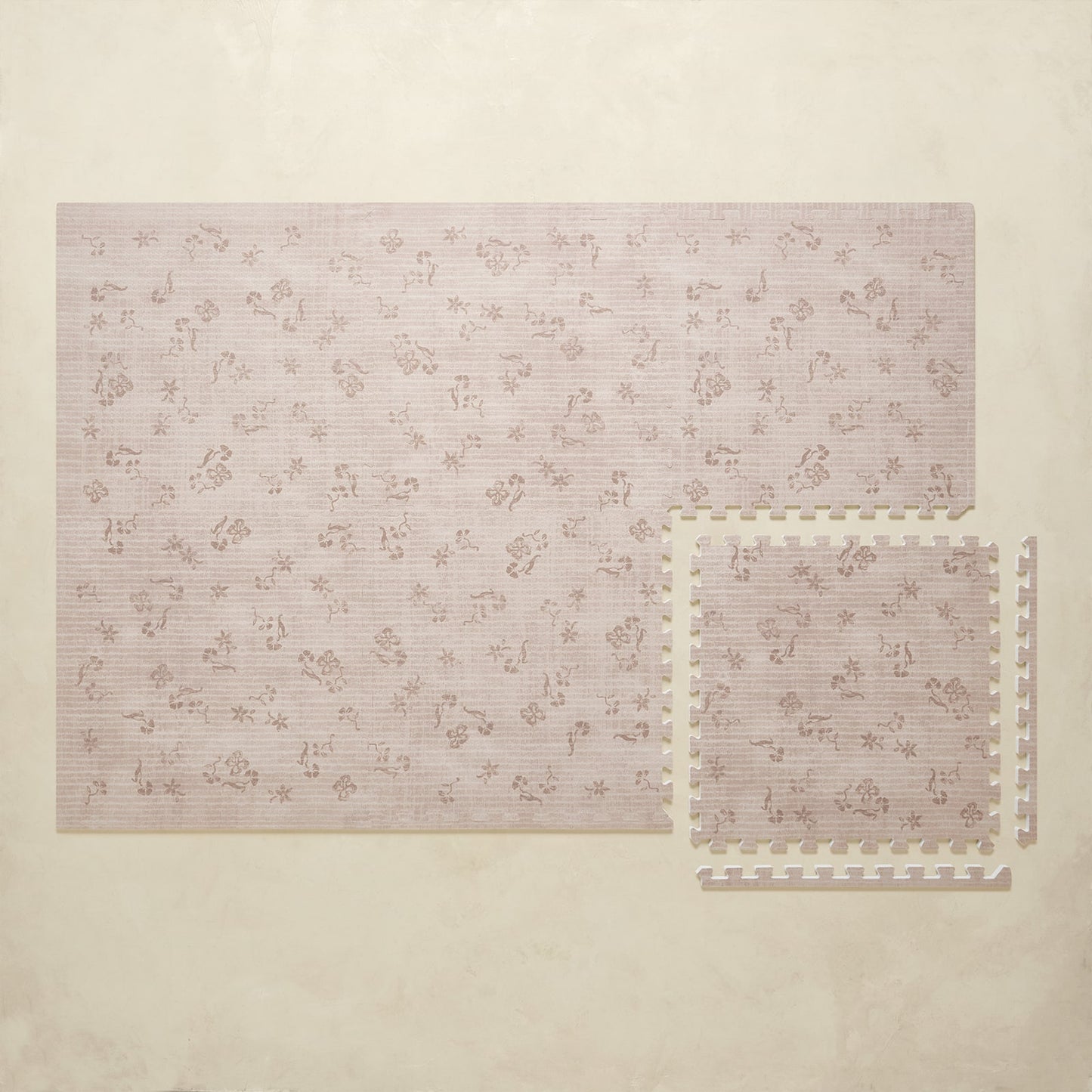 Floral patterned puzzle play mat on a beige background